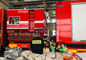 Uczniowie oglądają wyposażenie wozu strażackiego.