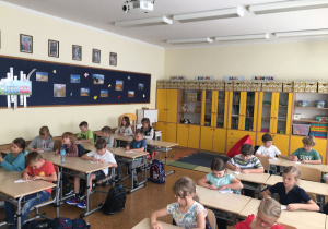 Uczniowie w trakcie składania kartki według kolejności pokazamej przez Adama.