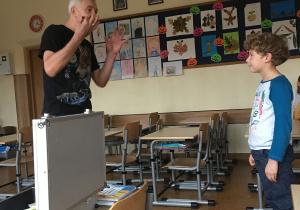 Jeden z uczniów, Bartosz, bierze udział w zabawie zaproponowanej przez Pana Tomasza.