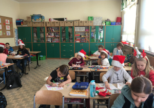 Uczniowie kolorują portrety Mikołaja.