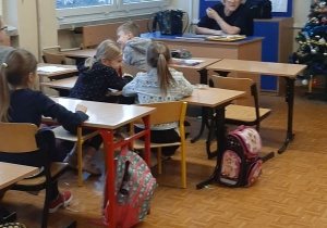 Nauczycielka prowadzi pogadankę na temat zaborów i walki Polaków o odzyskanie niepodległości.