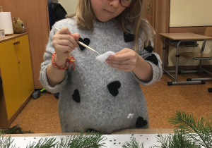 Ania przykleja płatki kosmetyczne.