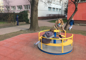 Tonia z Elą kręcą się na karuzeli, zaś Tymek z Kacprem grają w piłkę nożną.