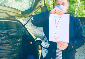 Mieszkaniec Powiśla trzyma w ręku kartkę ze znakiem interpunkcyjnym "!".