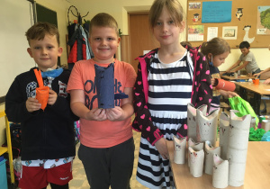 Adrian, Kacper i Dominika chwalą się swoimi pracami.