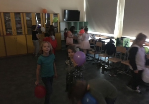 Dzieci tańczą i bawią się z balonami.