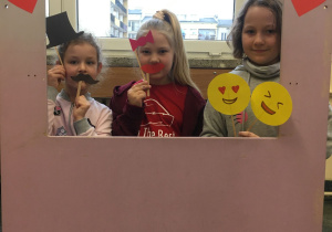 Natalka, Oliwia i Alicja pozują do zdjęcia w fotobudce.