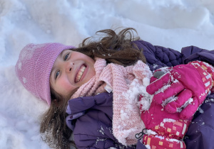 Małgosia robi aniołka na śniegu.