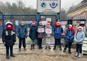 Uczniowie podczas wizyty w schronisku. Każdy ma na sobie czapke Mikołaja!