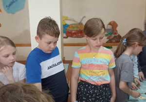Uczniowie uważnie słuchają Pani Marianny prowadzącej warsztaty.