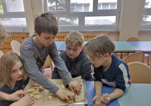 Po nałożeniu konfitury dzieci zawijają ciasto.