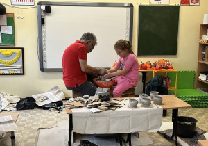 Amelka tworzy swój garnuszek na kole garncarskim.