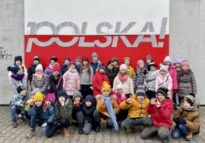Grupowe zdjęcie pod flagą Polski.