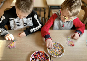 Artem i Kacper podczas układania koralików na szablonach.