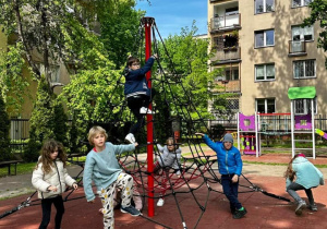 Dzieci szukają zagadek na zabawce ogrodowej.