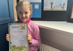 Roma z pięknym usmiechem prezentuje swój dyplom.