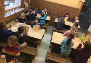 Uczniowie podczas ostatniej pracy szlifują i dekorują deski drewniane.