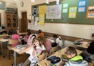Dzieci z klasy 2b rozwiązują łamigłówki z okazji Dnia Kropki.