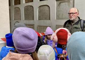 Uczniowie zatrzymali się przy katakumbach, aby posłuchać o ich historii.