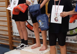 Adam stoi na podium podczas dekoracji medalami.
