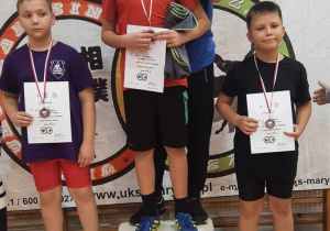 Karol stoi na podium podczas dekoracji medalami.