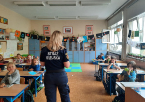 Funkcjinariuszka Straży Miejskiej wrowadza uczniów w temat zajęć.
