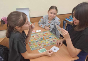 Uczennice przed rozpoczęciem gry czytają instrukcję.