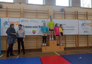 Karolina z klasy 6b stoi na podium, na drugim miejscu, podczas dekoracji medalami.