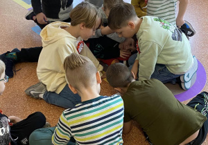 Uczniowie dzielą sie na grupy na korytarzu szkolnym.