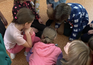 Uczniowie dzielą sie na grupy na korytarzu szkolnym.