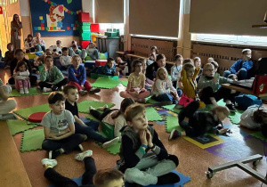 Uczniowie, siedząc i leżąc na materacach i pufach, oglądają film pod tytułem "Matylda".