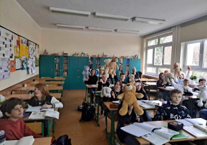 Uczniowie z klasy 6a siedzą w klasie i prezentują swoje Misie.