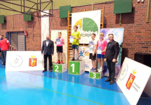 Uczniowie stoją na podium podczas dekoracji medalami.