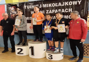Karol stoi na podium podczas dekoracji medalami.