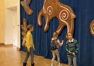 Uczniowie czekając na spektakl ogladaja wystawę teatralnych lalek.