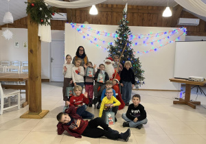 Klasa 1a wraz z wychowawczynią na spotkaniu z Mikołajem pozuje do grupowego zdjęcia.