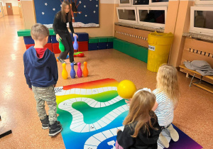Uczennica naszej szkoły gra z przyszłymi pierwszoklasistami w kręgle.