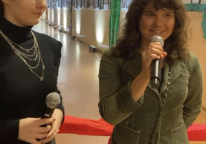 Zosia przemawia do zebranych gości i zaprasza do oglądania prac.