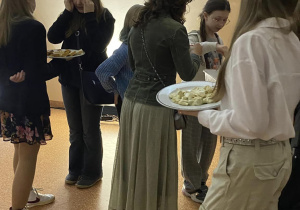 Uczniowie rozdają kanapeczki i pierożki.