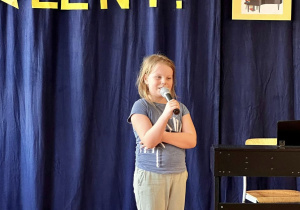 Amelia prezentuje talent wokalny wykonując piosenkę.