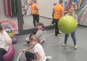 Uczennice w rolach instruktorek fitness testują sprzęt do ćwiczeń.
