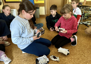 Maja i Lena dzielą tabliczki czekolady na kawałki.
