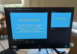Na monitorze kompuetra wyświetla się początek prezenacji "Definicja wolontariatu".