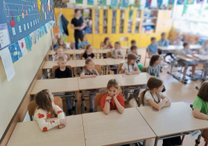 Uczniowie z klasy 1b siedzą w ławkach i oglądają prezentację.