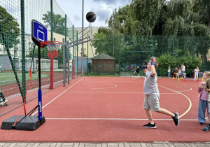 Jacob rzuca piłką do kosza.