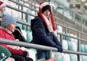 Uczniowie siedzą na trybunie stadionu i słuchają historii klubu.