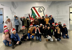 Grupowe zdjęcie przy herbie Legii Warszawa.