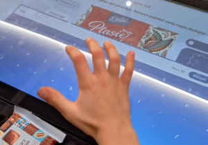 Dziecko stoi przy tablecie i projektuje opakowanie Ptasiego Mleczka.