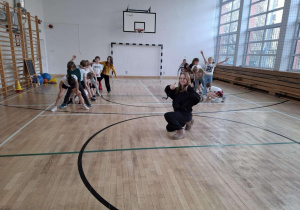 Uczniowie z wychowawcą w oczekiwaniu na konkurencję sportową.