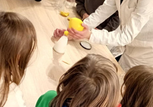 Uczniowie przyglądają się doświadczeniu wykonywanym przez prowadzącego..